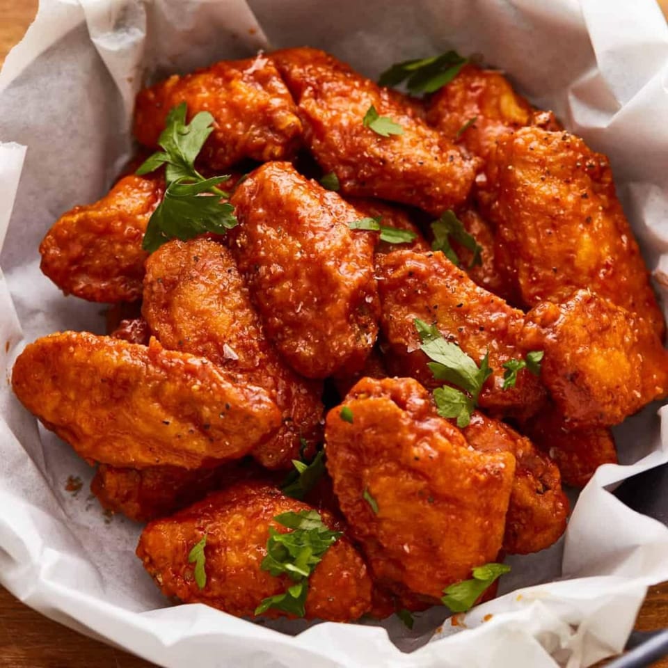 A basket of saucy chicken wings, garnished with fresh parsley, from Roma Pizza & Pasta.