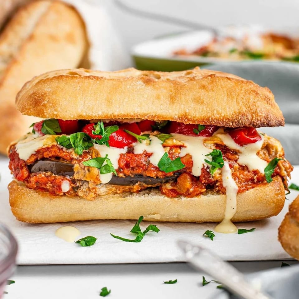 A close-up of a Roma Pizza & Pasta eggplant parmesan sub with melted cheese and sauce.
